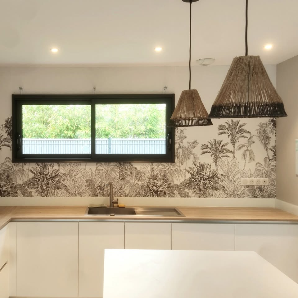 Décor mural imprimé jungle noir et blanc autour d’une fenêtre dans une cuisine de particulier
