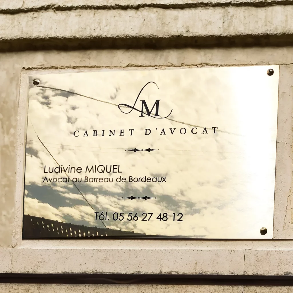 Plaque professionnelle en laiton installée sur une façade à Bordeaux