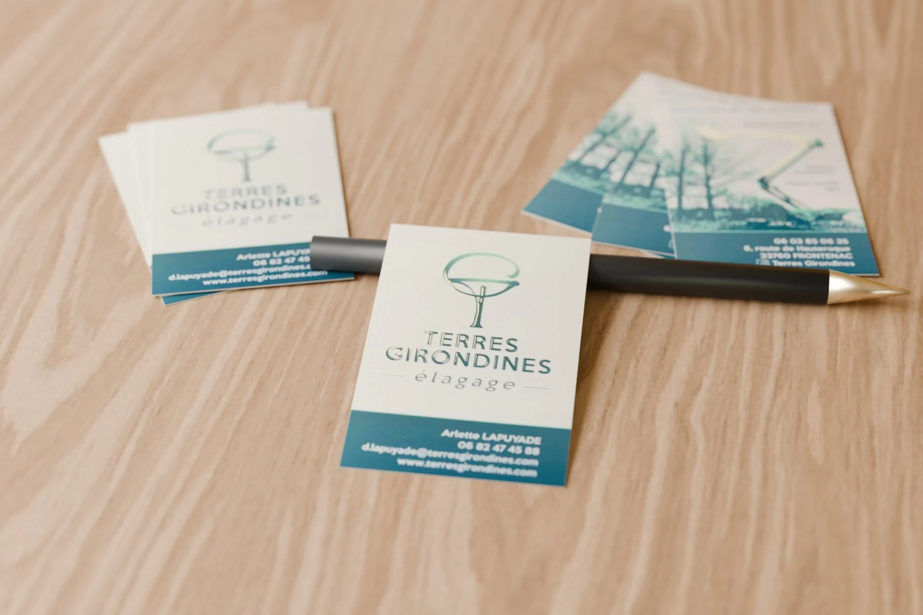 Cartes de visite recto verso pour une entreprise d’élagage, posées sur une table en bois