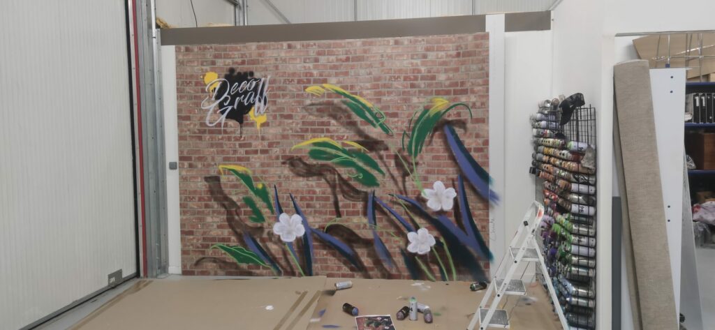 Décor peint feuilles tropicales et lettrage Déco Graff sur fond briques – stand Foire de Bordeaux