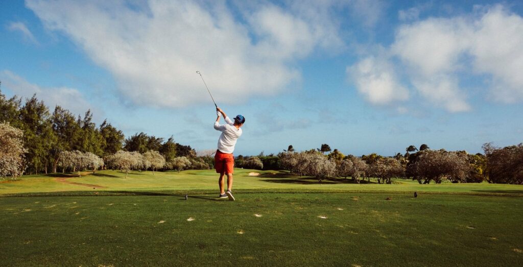 Golfeur au swing sur un parcours