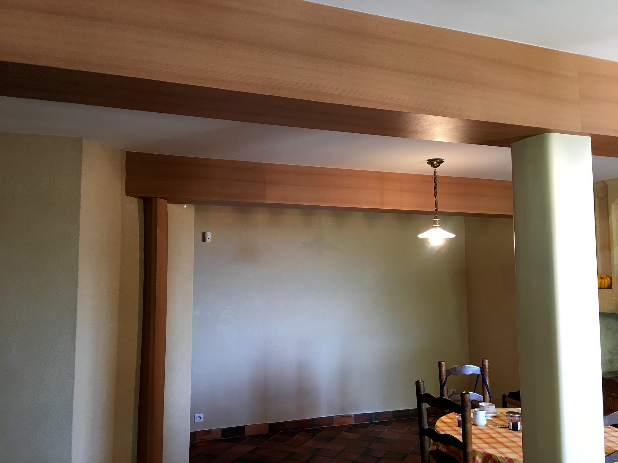 Poutres et poteaux habillés d’un film adhésif décoratif effet bois dans une pièce à vivre