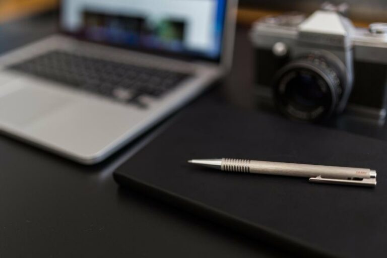 Illustration : carnet noir et stylo sur un bureau