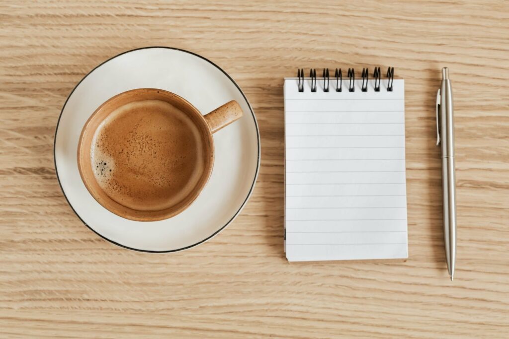 Bloc-notes et stylo métal sur bois