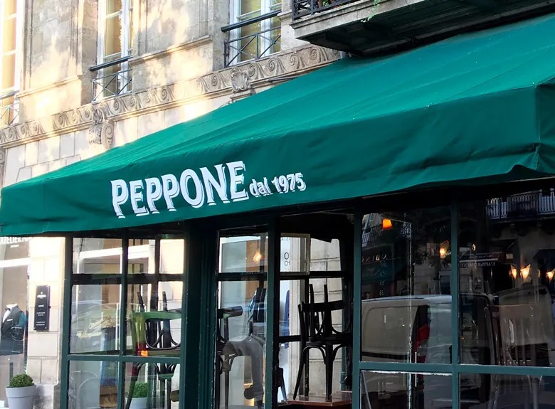 Store banne sur mesure au-dessus de la véranda d’un restaurant, réalisation Allgraphik